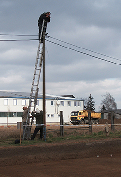 Archäologie mit Leiter auf Telefonmast